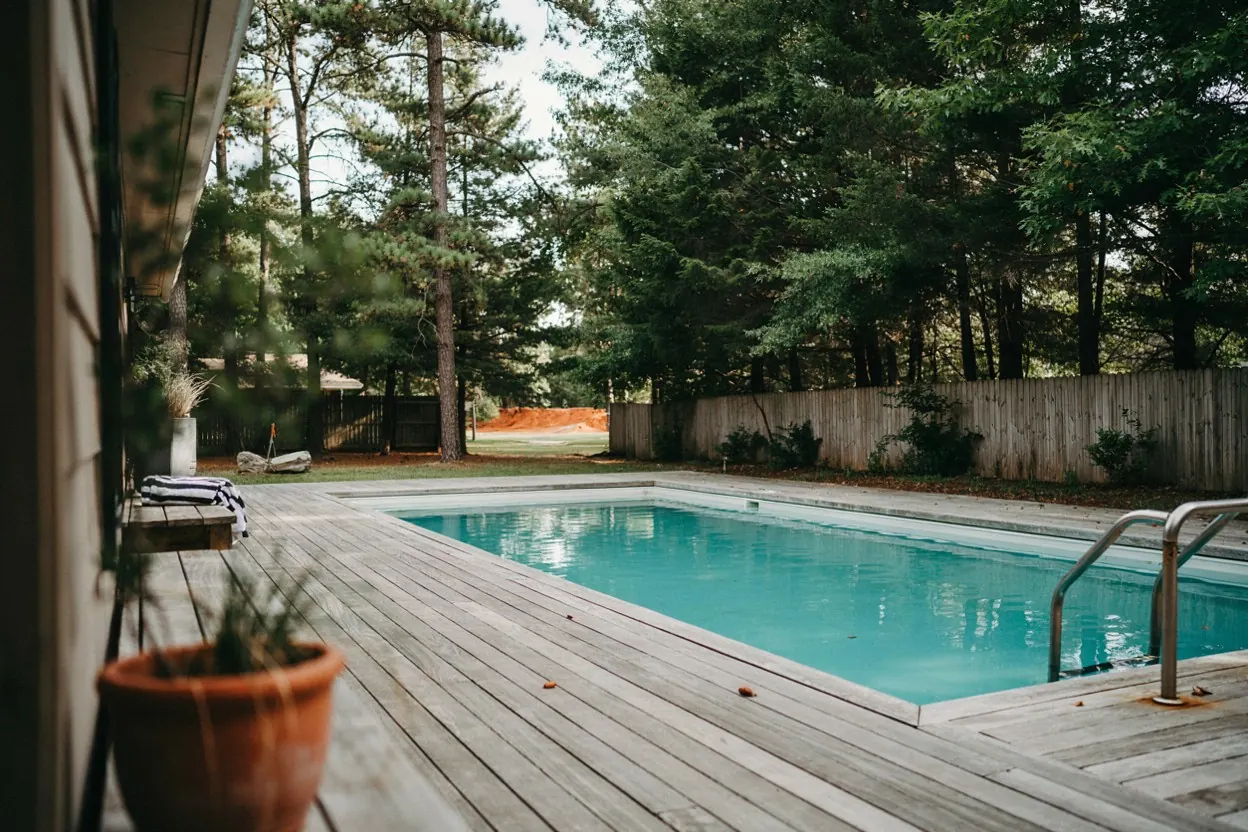 East Texas backyard pool surrounded by tall pines