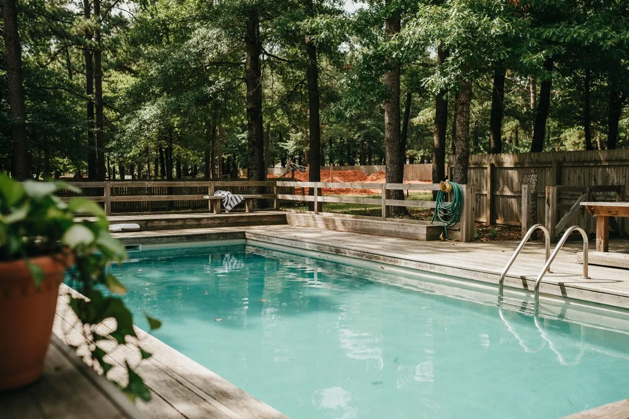 East Texas backyard pool surrounded by tall pines