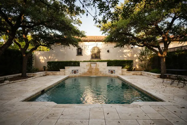 San Antonio backyard pool with a limestone waterfall under live oaks